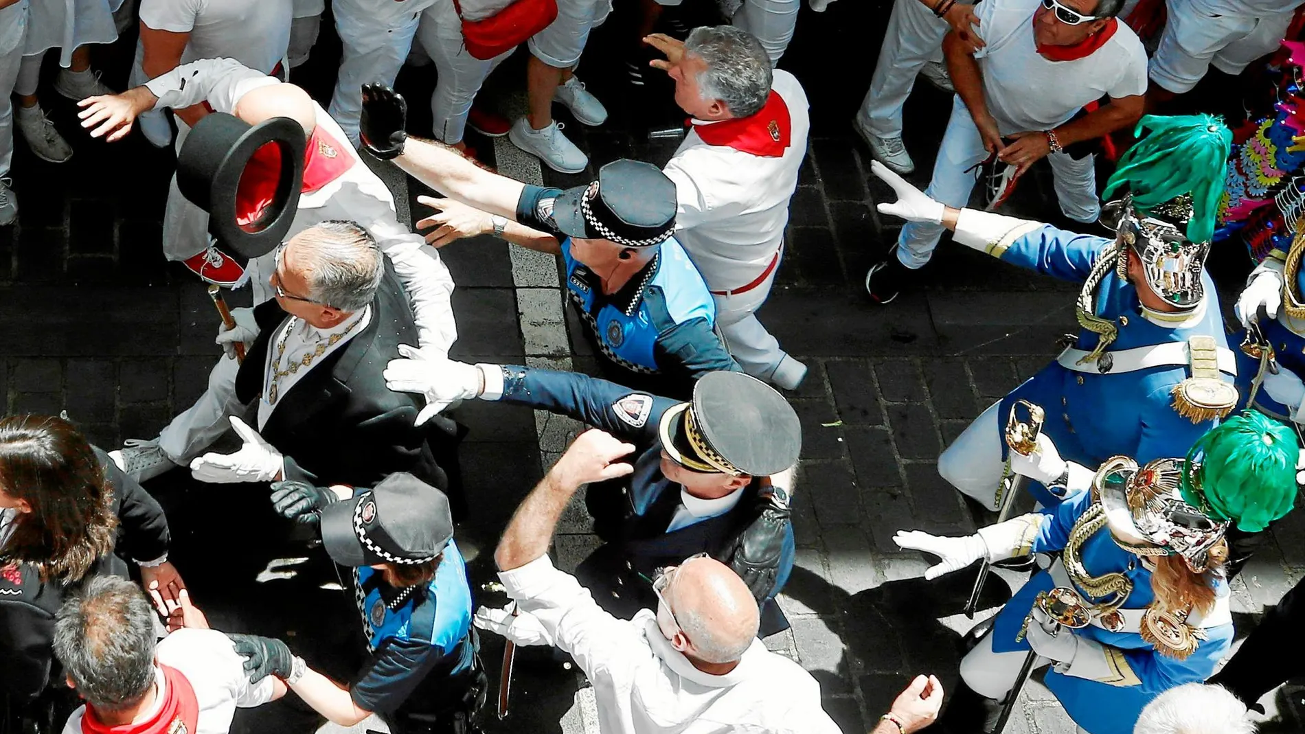 Momentos de tensión al paso de la corporación municipal. Agentes de la Policía Municipal protegen al alcalde, Enrique Maya