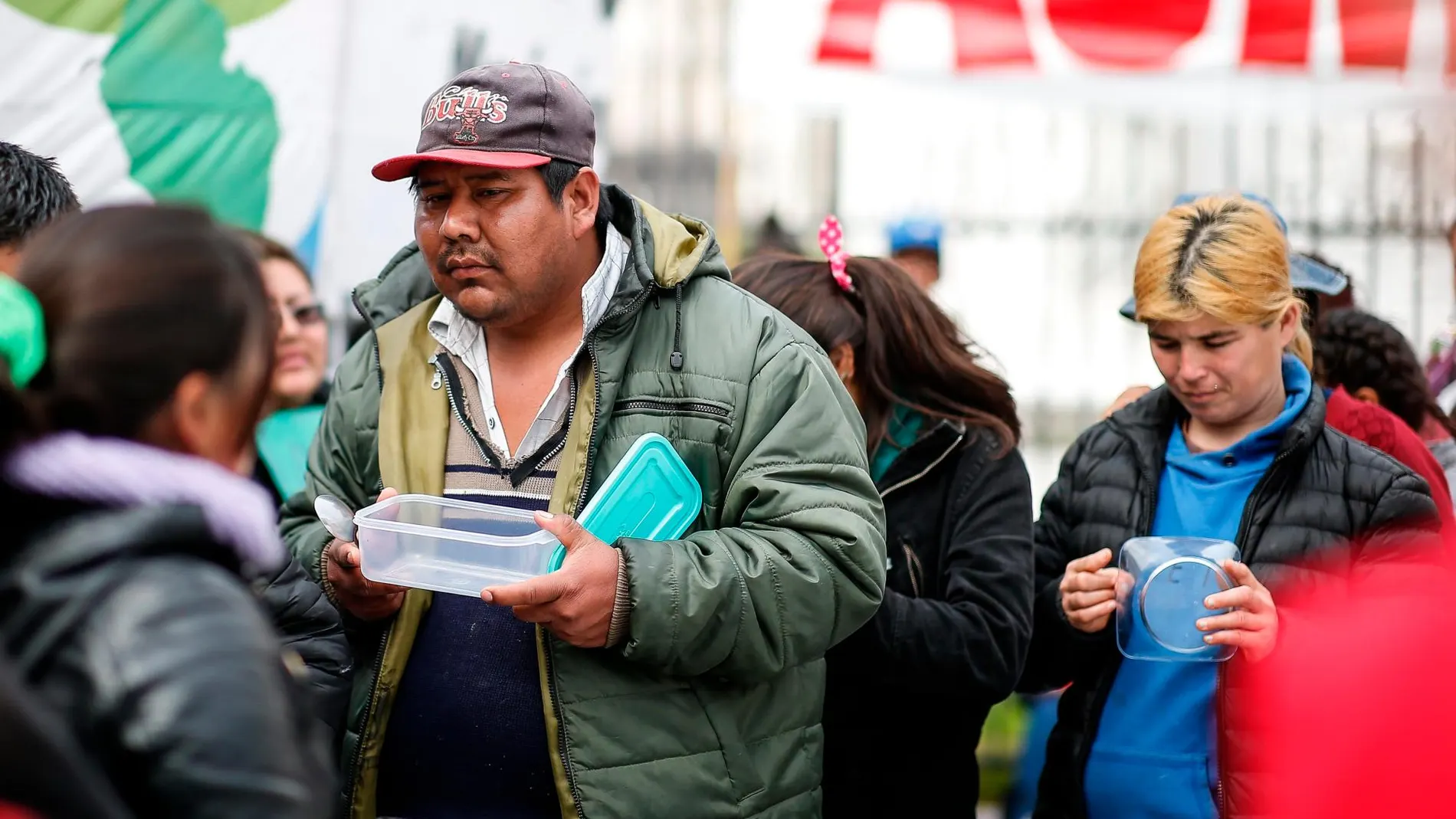 Un hombre espera a recibir comida mientras organizaciones sociales acampan a la espera de que se declare la emergencia alimentaria que reclaman este miércoles, en la Plaza de Mayo, en Buenos Aires