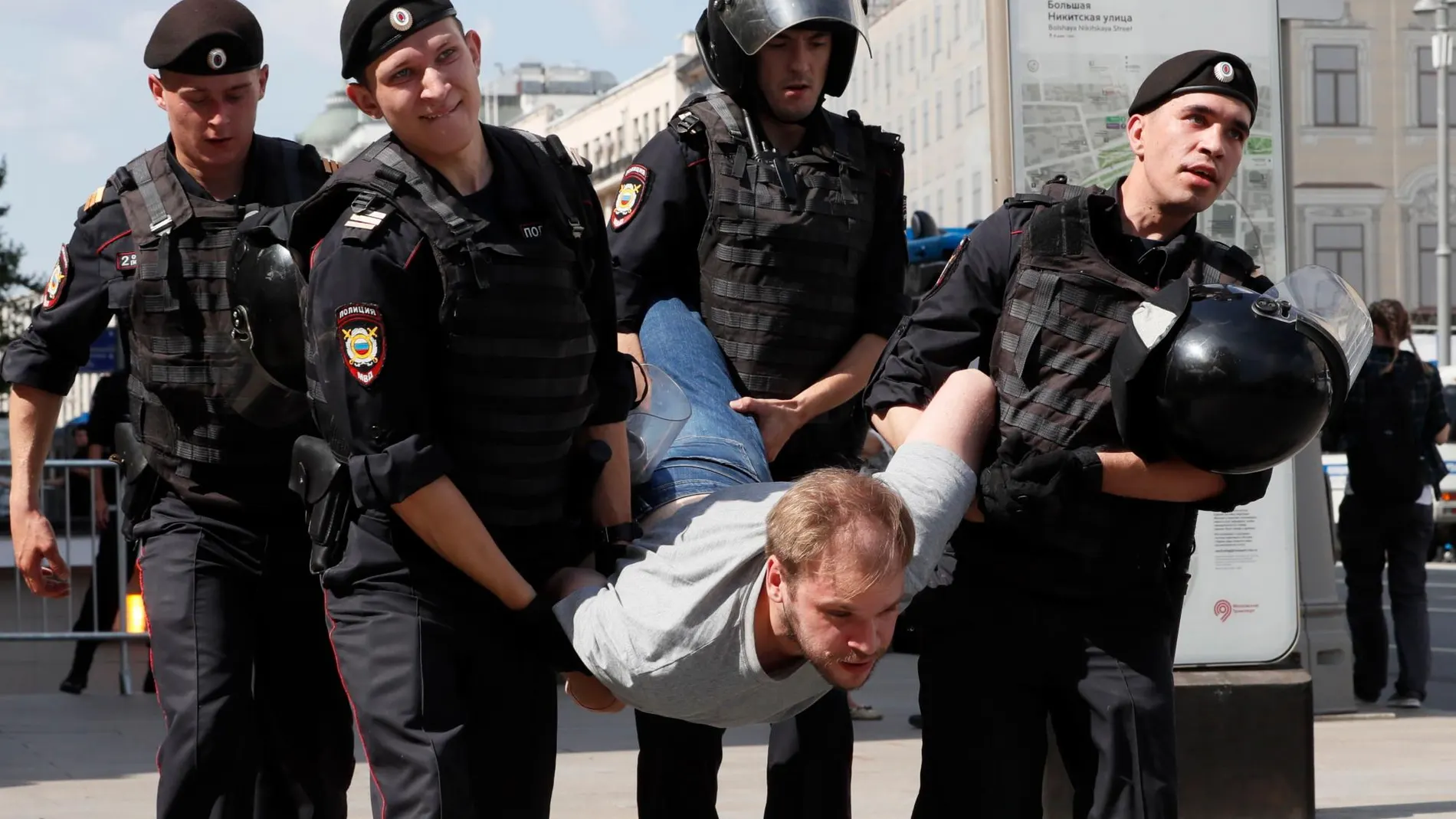 Agentes de policía detienen a uno de los manifestantes