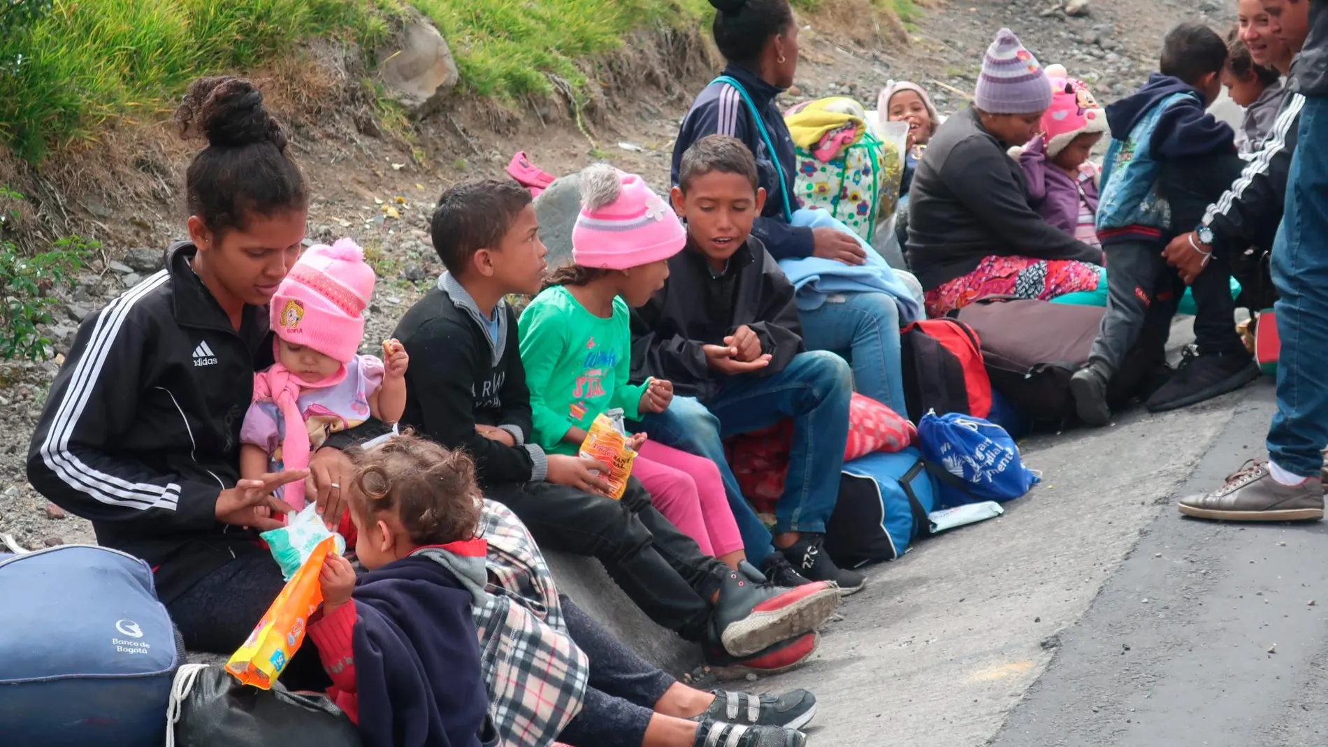 Familias venezolanas esperan este martes en una carretera del paso de Rumichaca, frontera entre Colombia y Ecuador/Efe