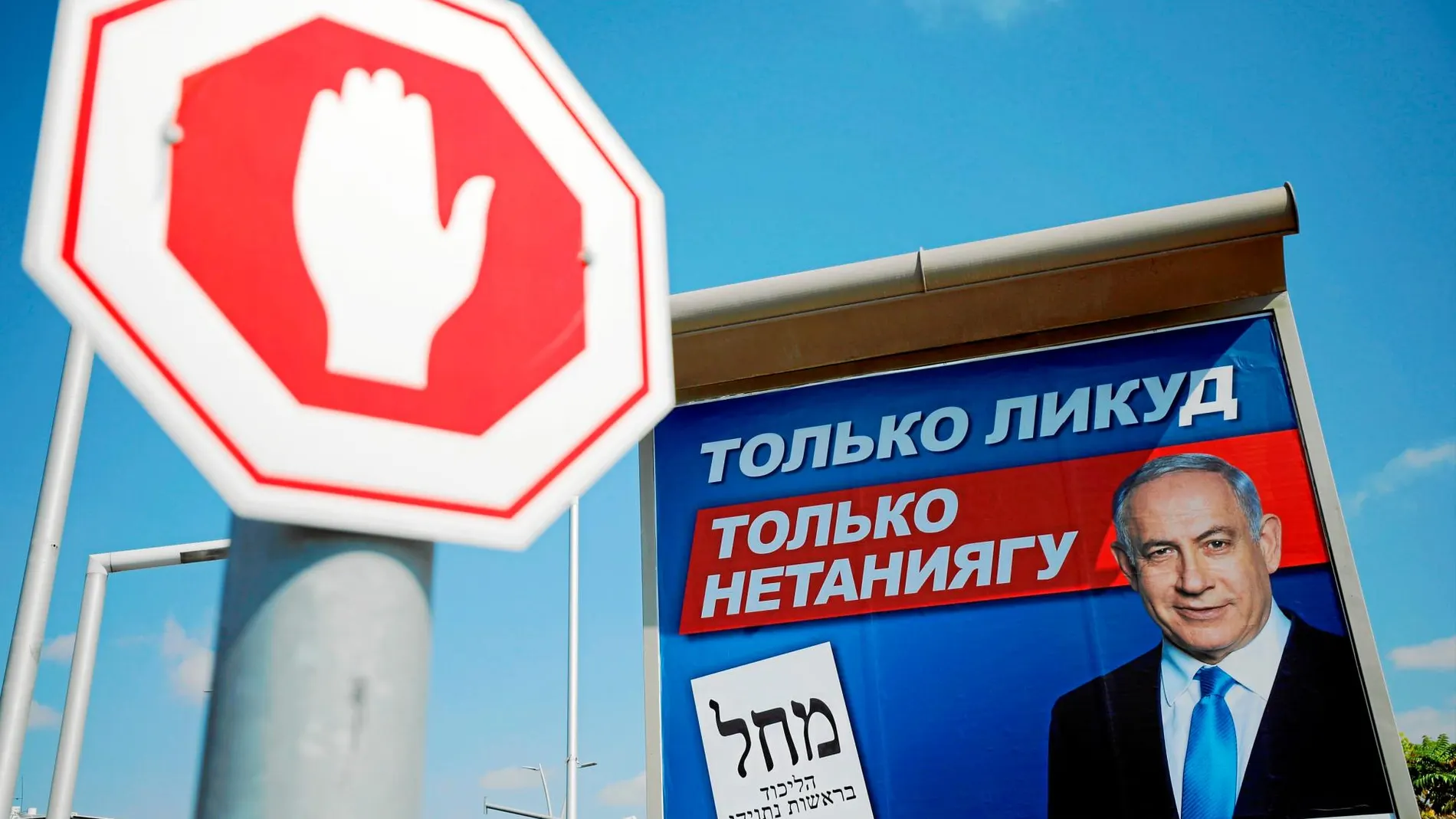 Un cartel electoral del partido Likud escrito en ruso cerca de una señal de tráfico en Ashdod, Israel