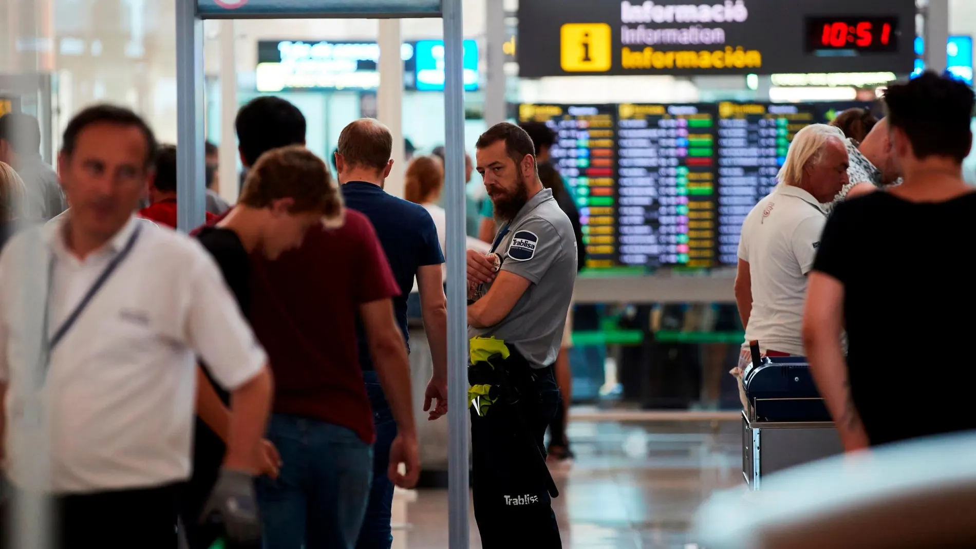 Pasajeros pasan los controles de seguridad en el aeropuerto de Barcelona-El Prat