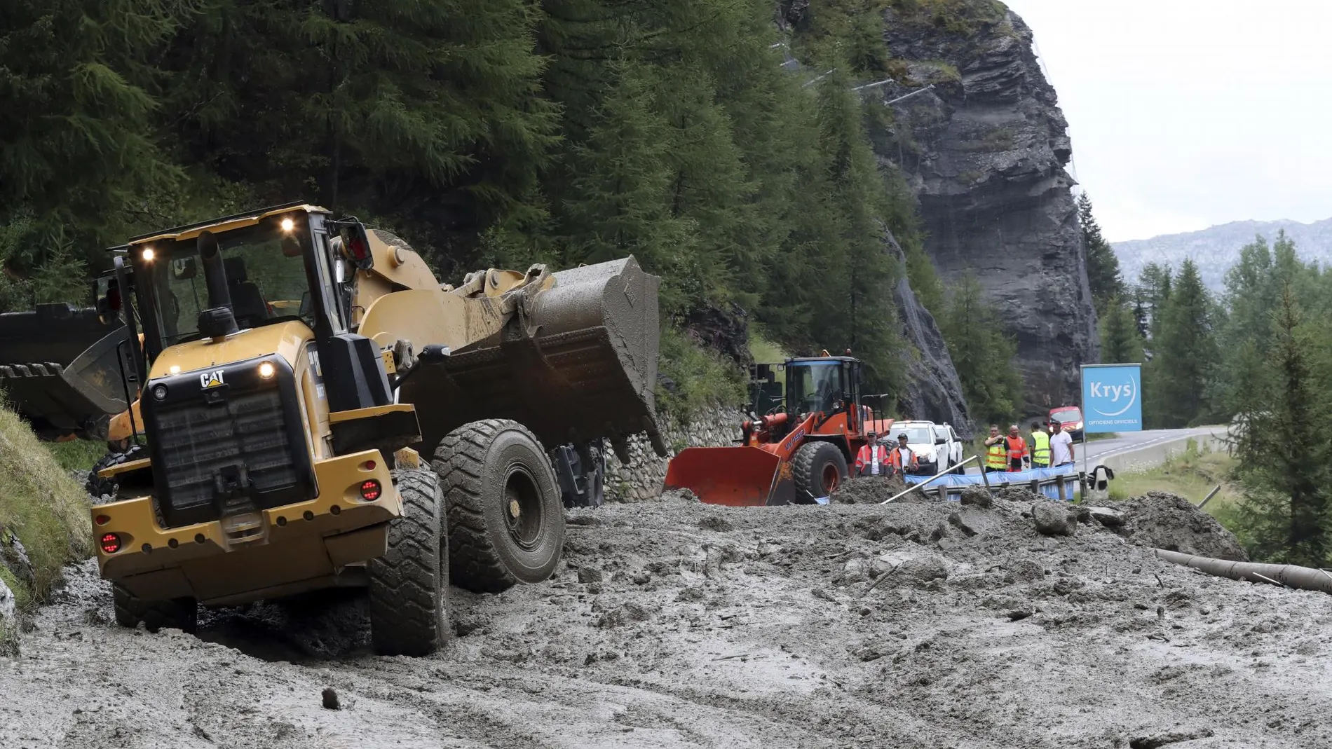 Las máquinas tratan de limpiar la carretera llena de barro