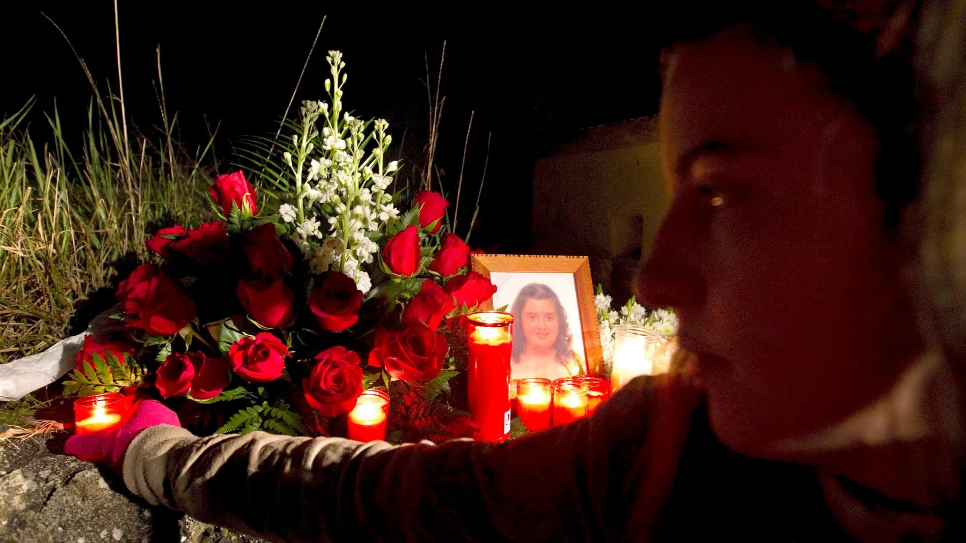 Una joven coloca una vela frente a la fotografía de María Esther Jiménez, la niña de 13 años asesinada por “El Vaca”