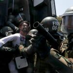 Policías detienen a un manifestante en Santiago de Chile hoy domingo, 20 de octubre. (AP Photo/Esteban Felix)