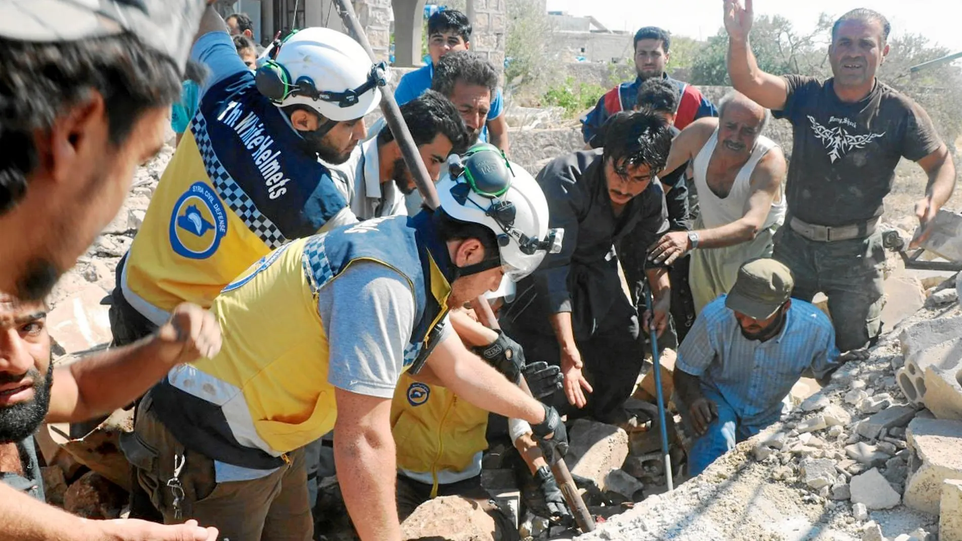 «Cascos blancos» sirios trabajan en el rescate de víctimas de un bombardeo en la ciudad de Kfar Rouma, en la provincia de Idlib