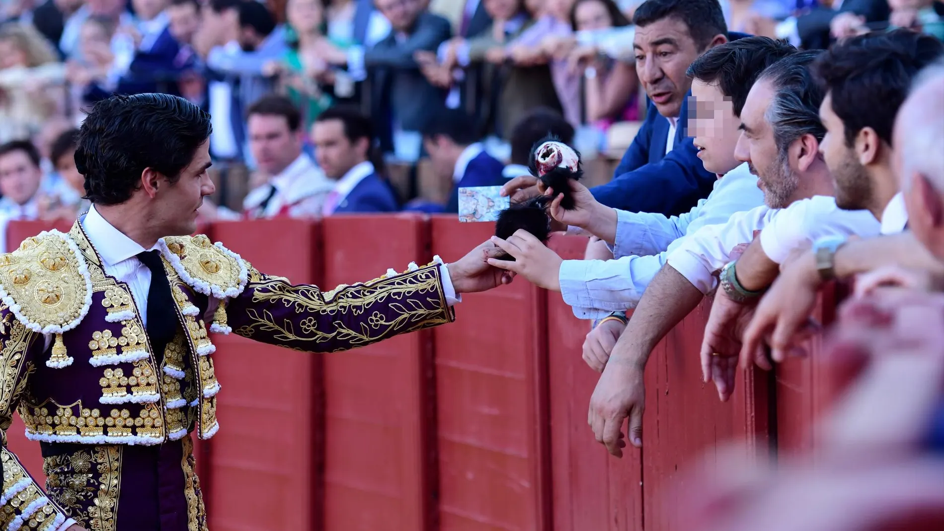 Pablo Aguado entrega a un niño una de las orejas de su triunfo en mayo