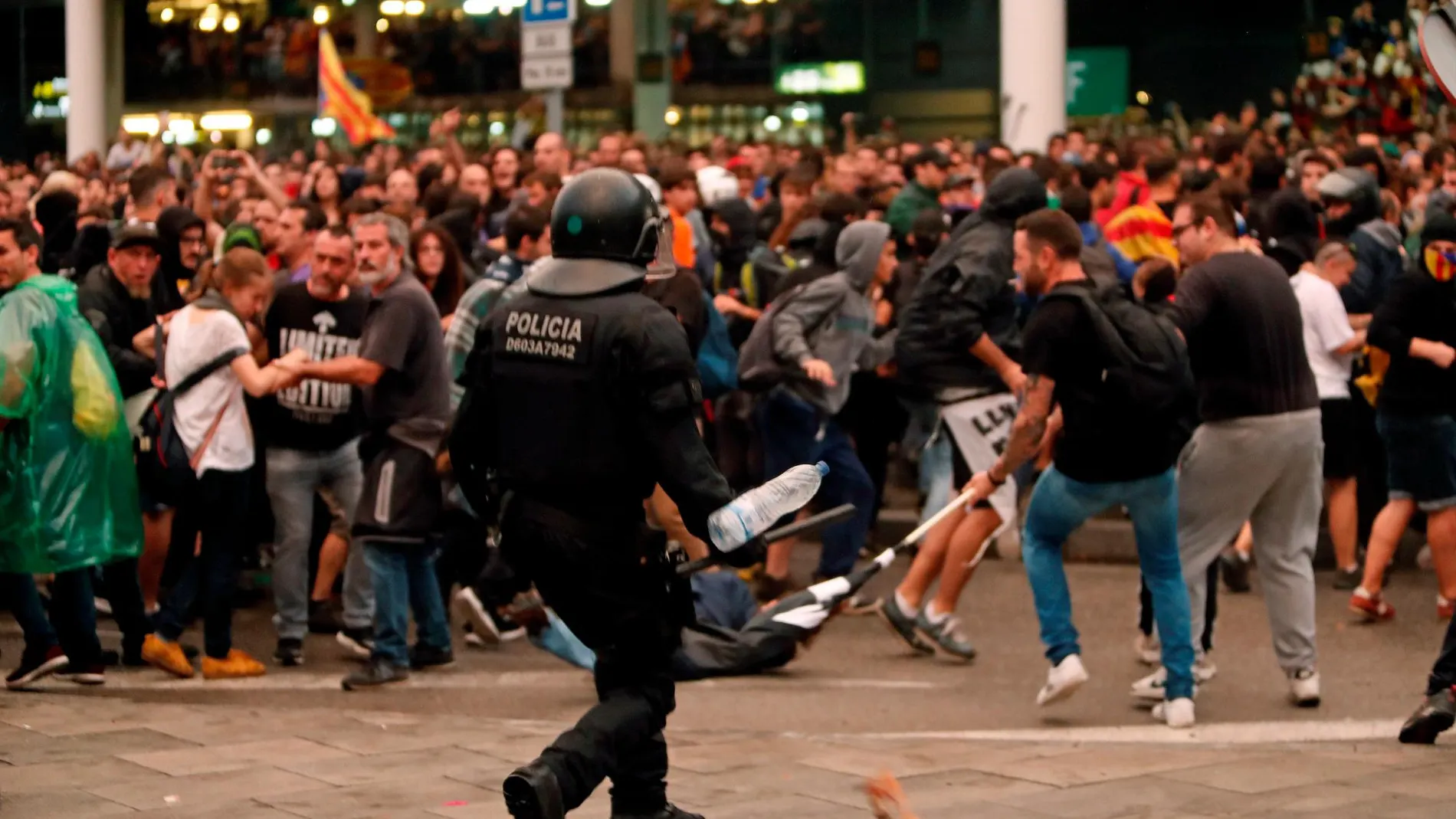 Un mosso durante una de las cargas contra las miles de personas se agolpan ante el Aeropuerto del Prat. EFE/Toni Albir