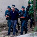 Agentes de la Guardia Civil trasladan a una de las nueve personas detenidas. EFE/Quique Garcia