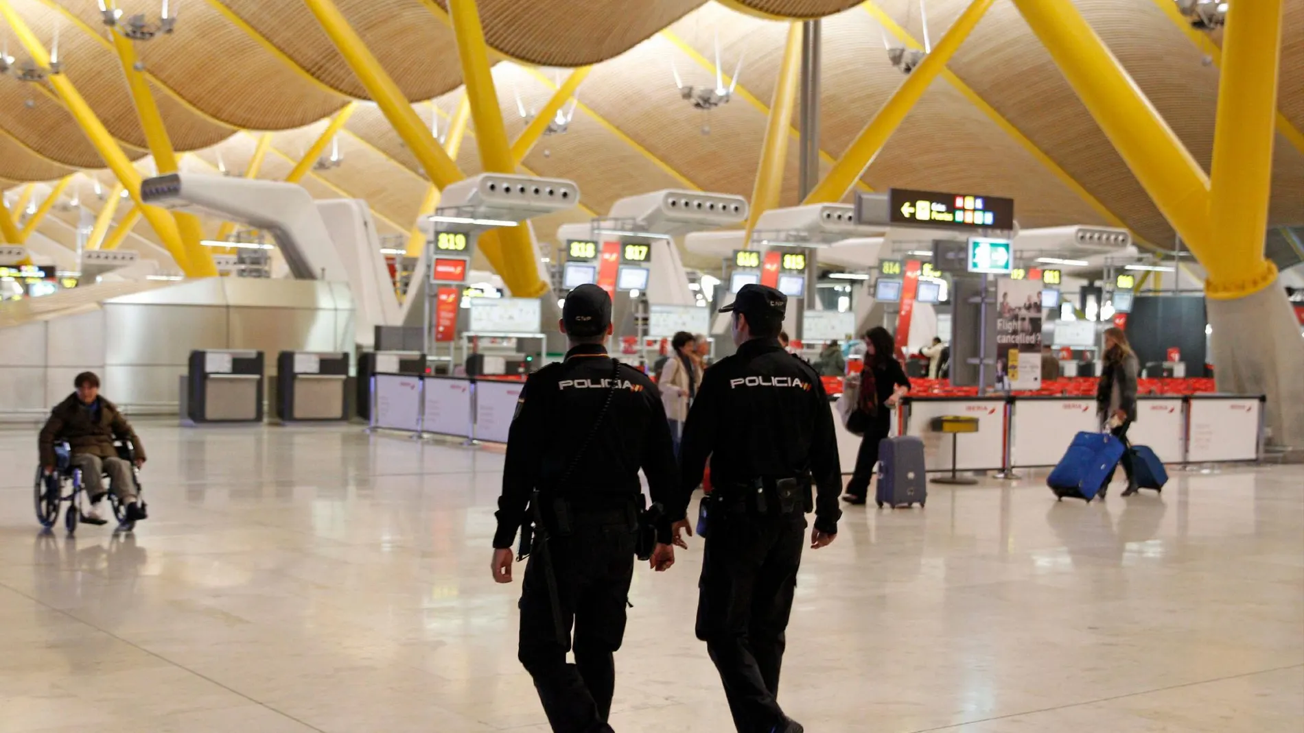 Efectivos policiales patrullan la T-4 del aeropuerto de Madrid Barajas, en una imagen de archivo