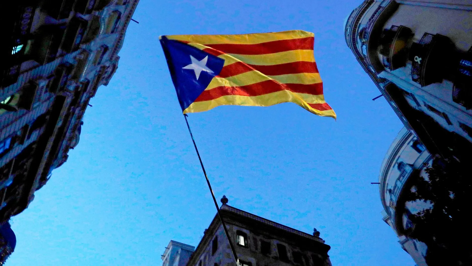Una bandera independentista ondea en una concentración contra el fallo del «procés» en Barcelona, que hoy vivirá una nueva jornada de protestas