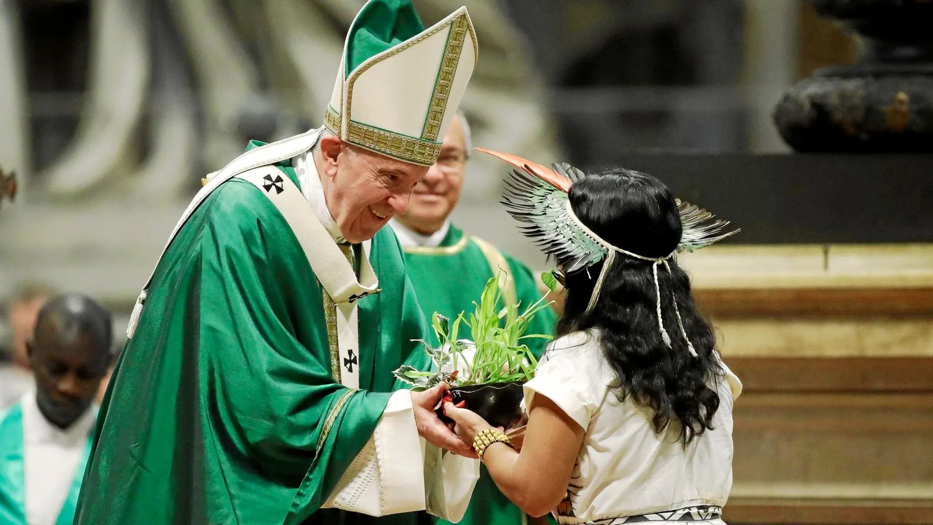 Una niña indígena entrega al Papa una planta como ofrenda, ayer en la misa tras el Sínodo / Ap
