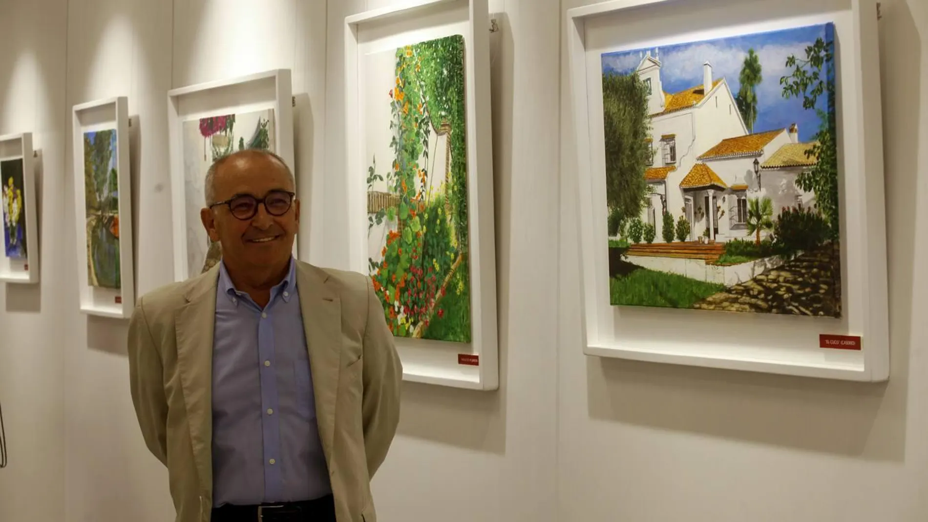 El pintor Alfonso Leal posa junto a sus obras expuestas en la sede de la Fundación Caja Rural del Sur de Sevilla / La Razón