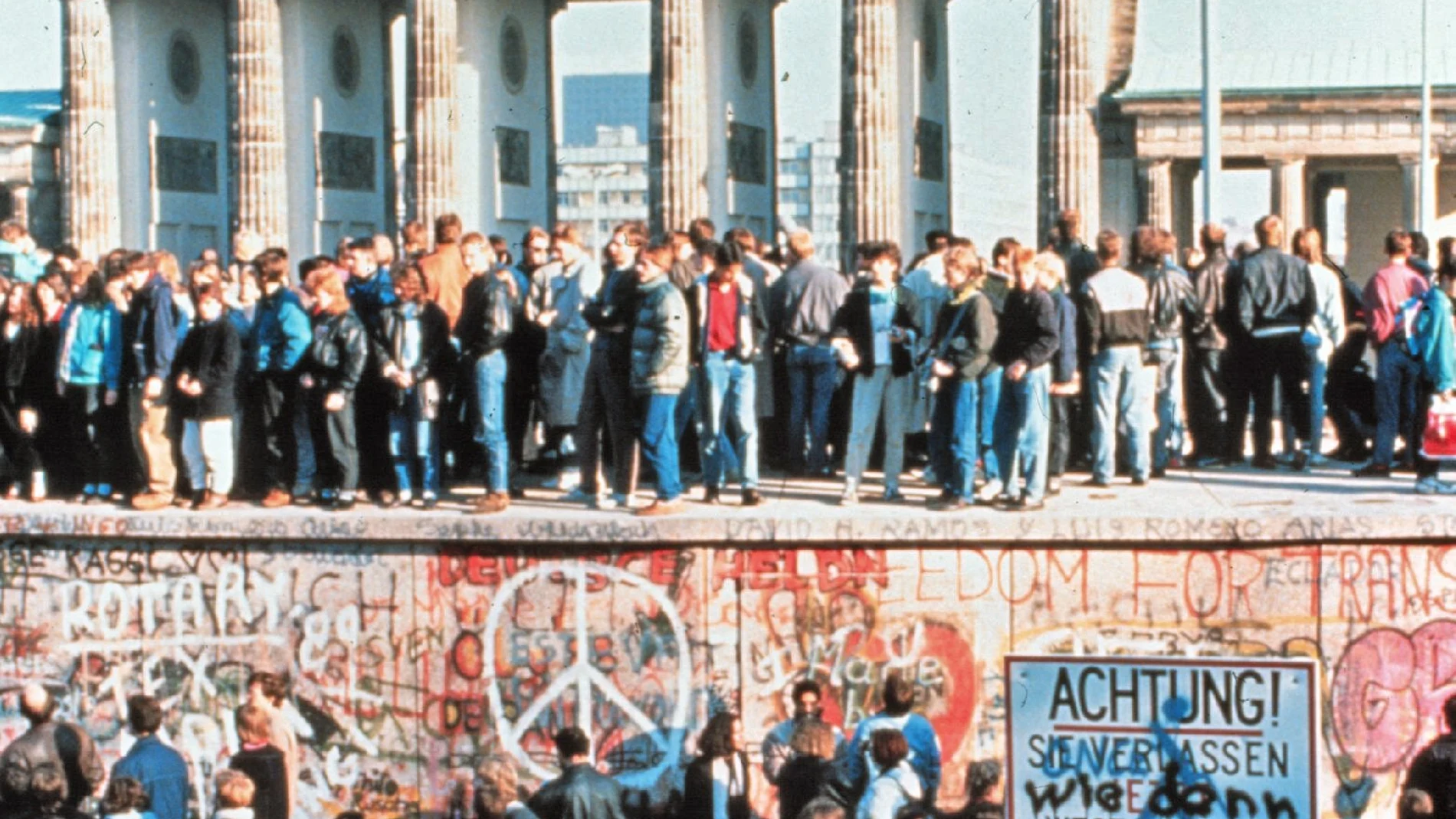 Miles de ciudadanos de las dos Alemanias celebran la caída del muro frente a la Puerta de Brandeburgo el 9 de noviembre de 1989