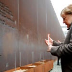 La canciller Angela Merkel enciende una vela en el memorial de la ciudad dividida a las víctimas de la tiranía comunista durante el 30º aniversario de la caída del Muro de Berlín