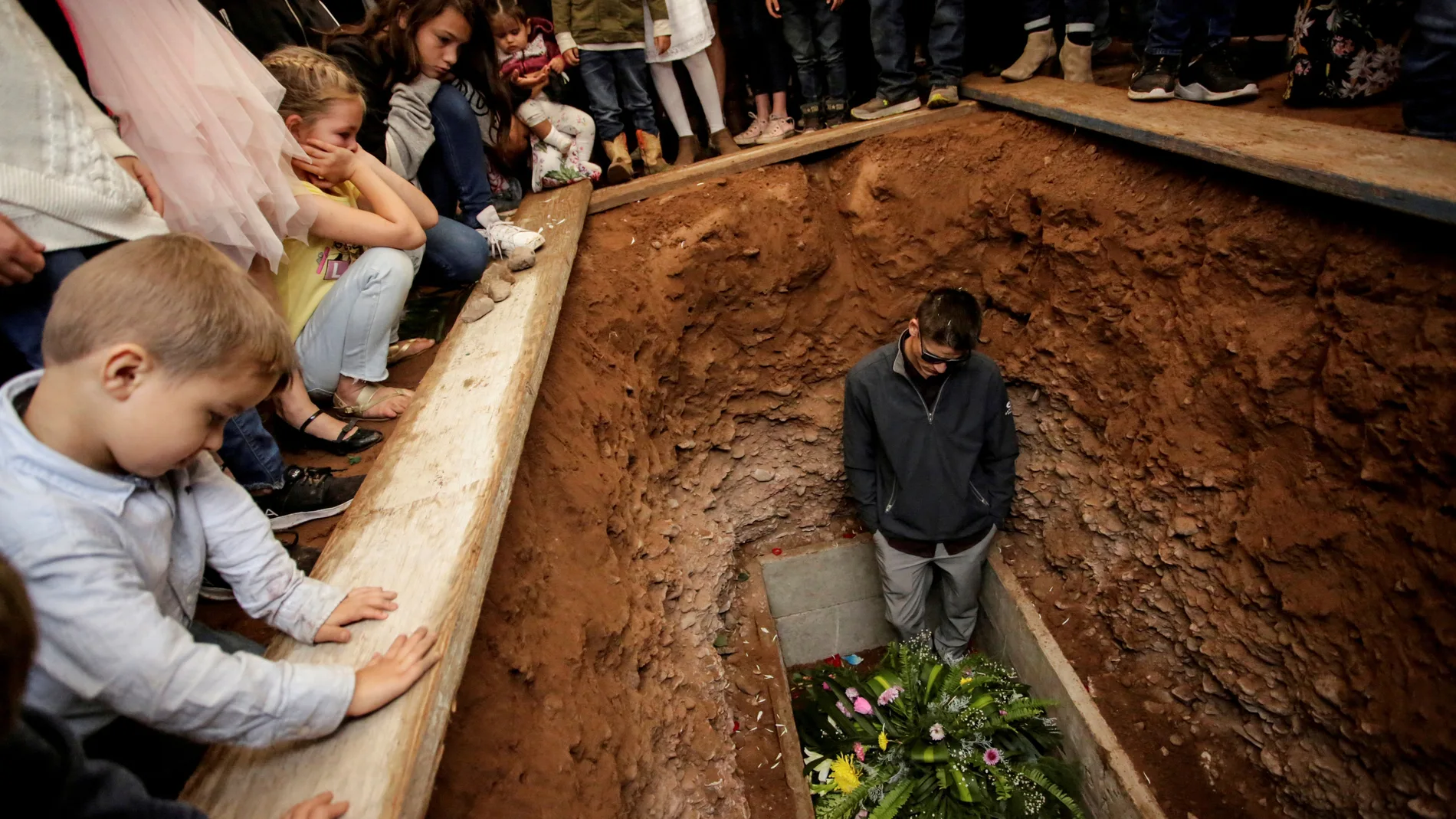 FILE PHOTO: A relative reacts during the burial of Miller and her children who were killed by unknown assailants in LeBaron