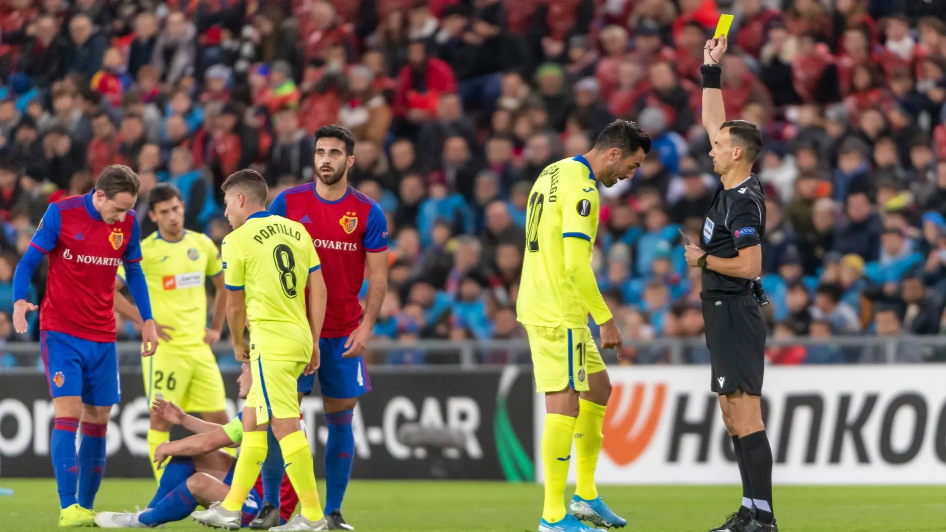 El arbitro ucraniano en seña la cartulina amarilla a Enric Gallego (AP)