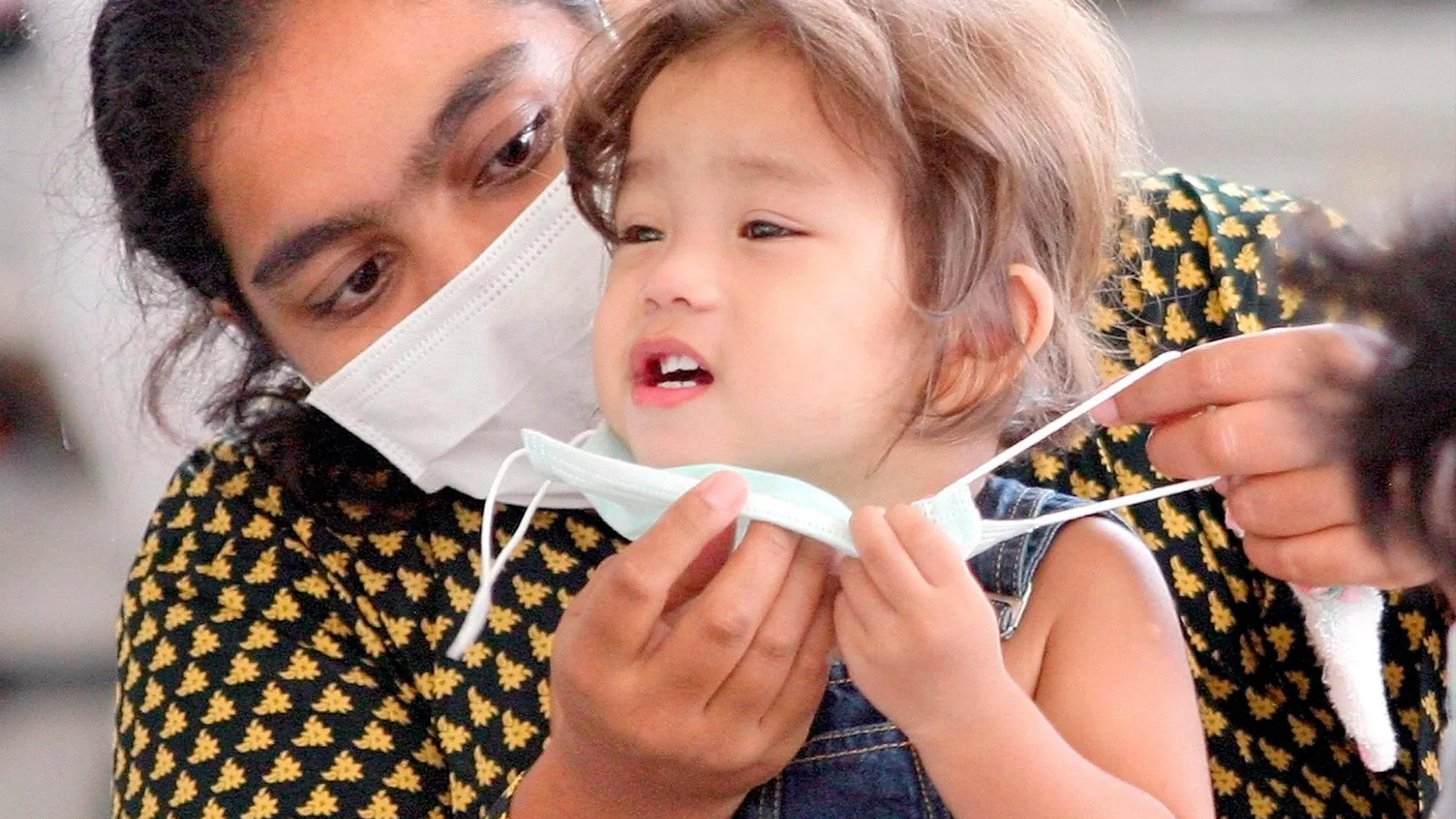Madre e hija en un hospital de Singapur haciendo uso de mascarillas preventoras