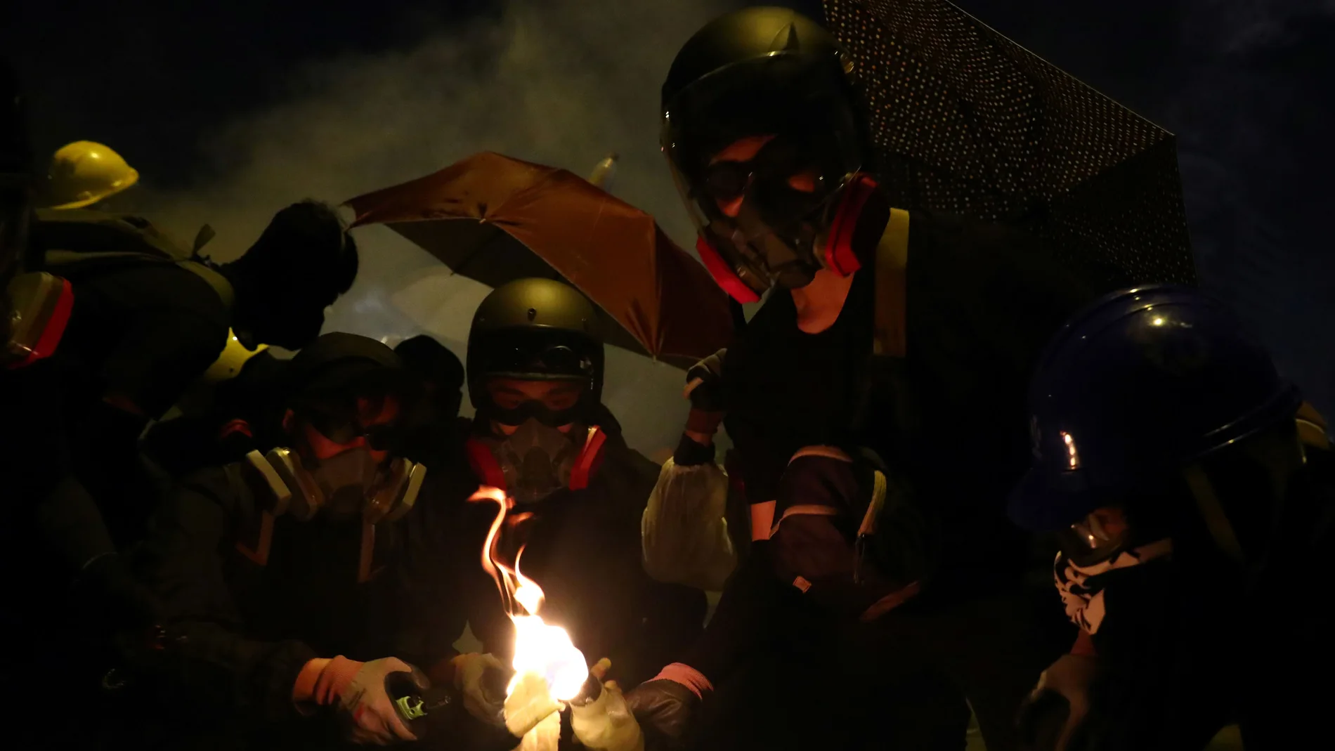 Anti-government protesters prepare molotov cocktails during clashes with police, outside Hong Kong Polytechnic University