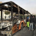 Varios curiosos contemplan un autobús incendiado en la ciudad de Isfahan durante las protestas de la pasada noche