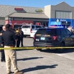 Agentes de policía trabajan en en el supermercado donde dos hombres y una mujer murieron en un tiroteo. Dos víctimas murieron en el interior del coche y la tercera en el aparcamiento.