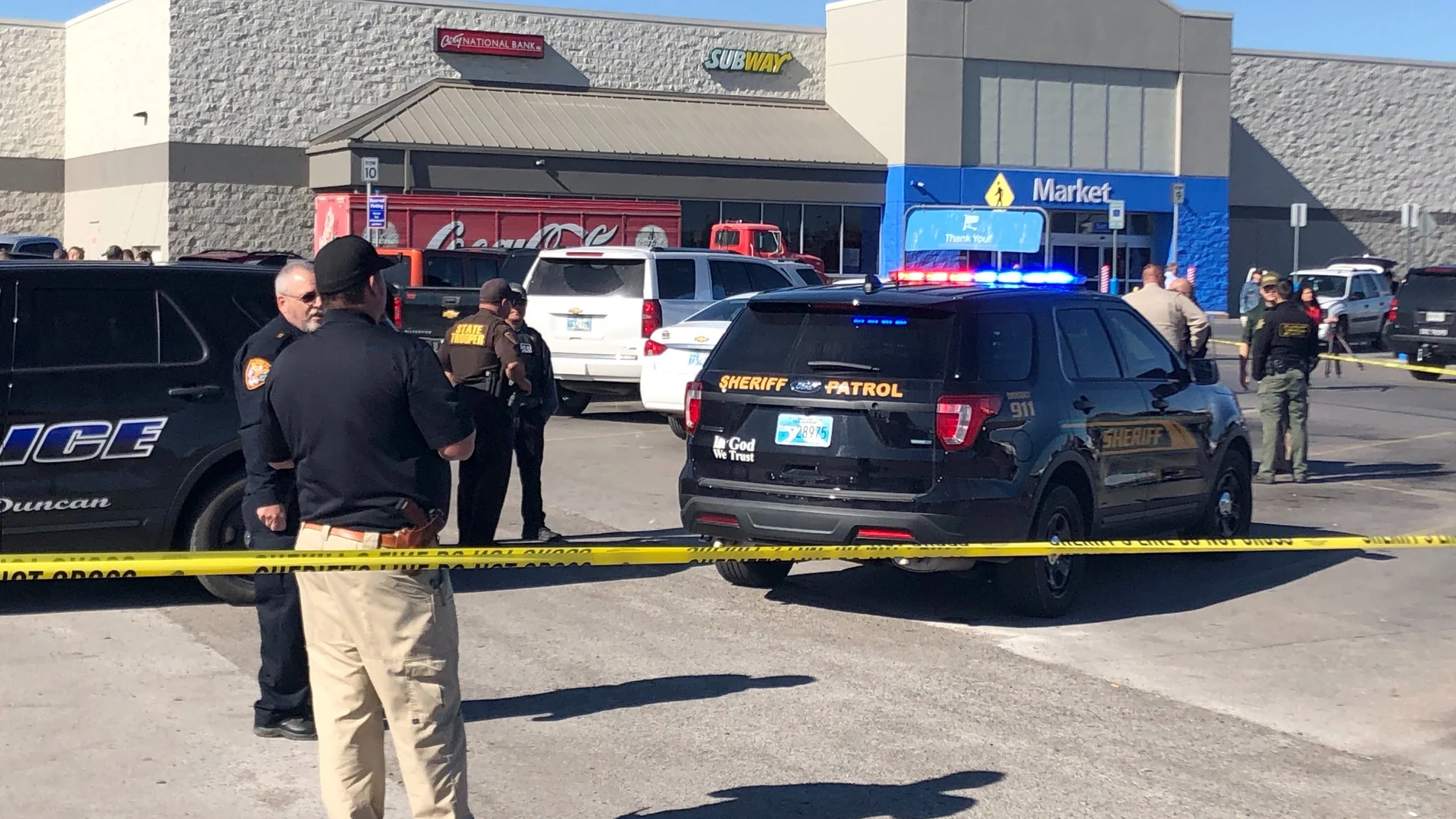 Agentes de policía trabajan en en el supermercado donde dos hombres y una mujer murieron en un tiroteo. Dos víctimas murieron en el interior del coche y la tercera en el aparcamiento.