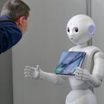Un hombre interacciona con un robot que utiliza inteligencia artificial