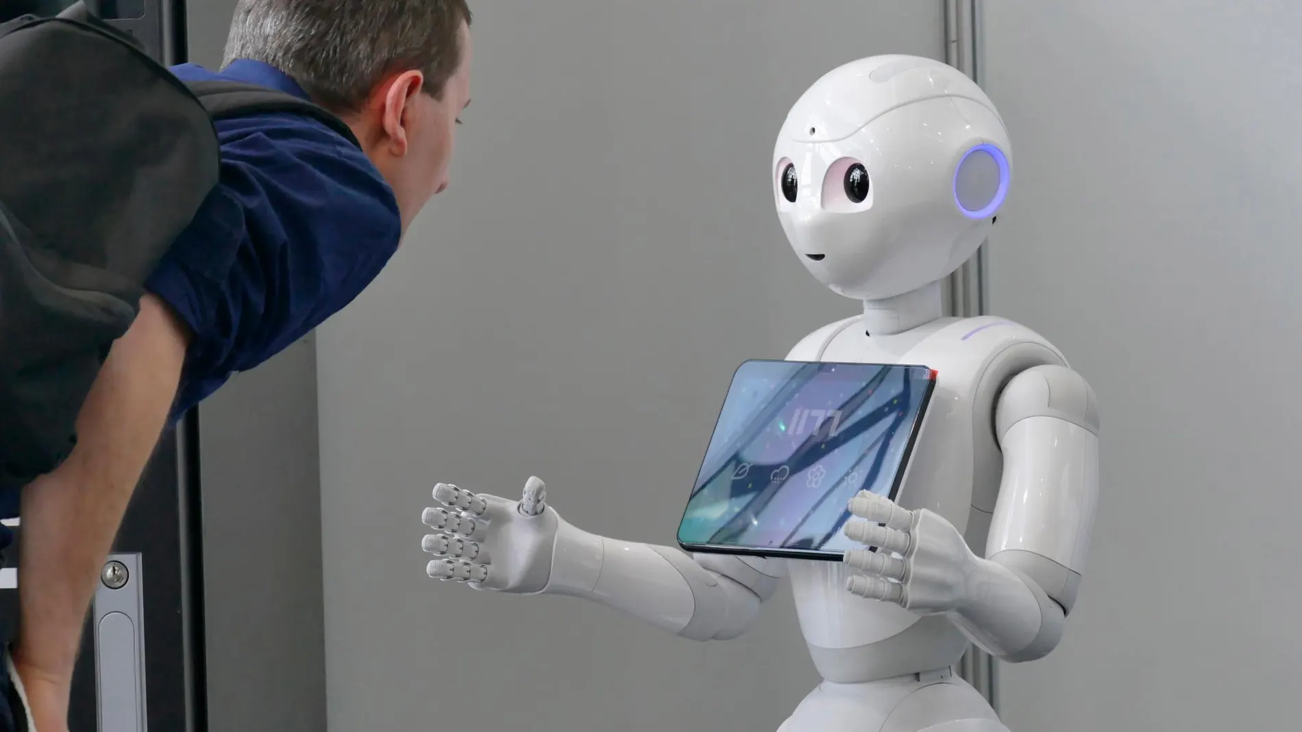 Un hombre interacciona con un robot que utiliza inteligencia artificial