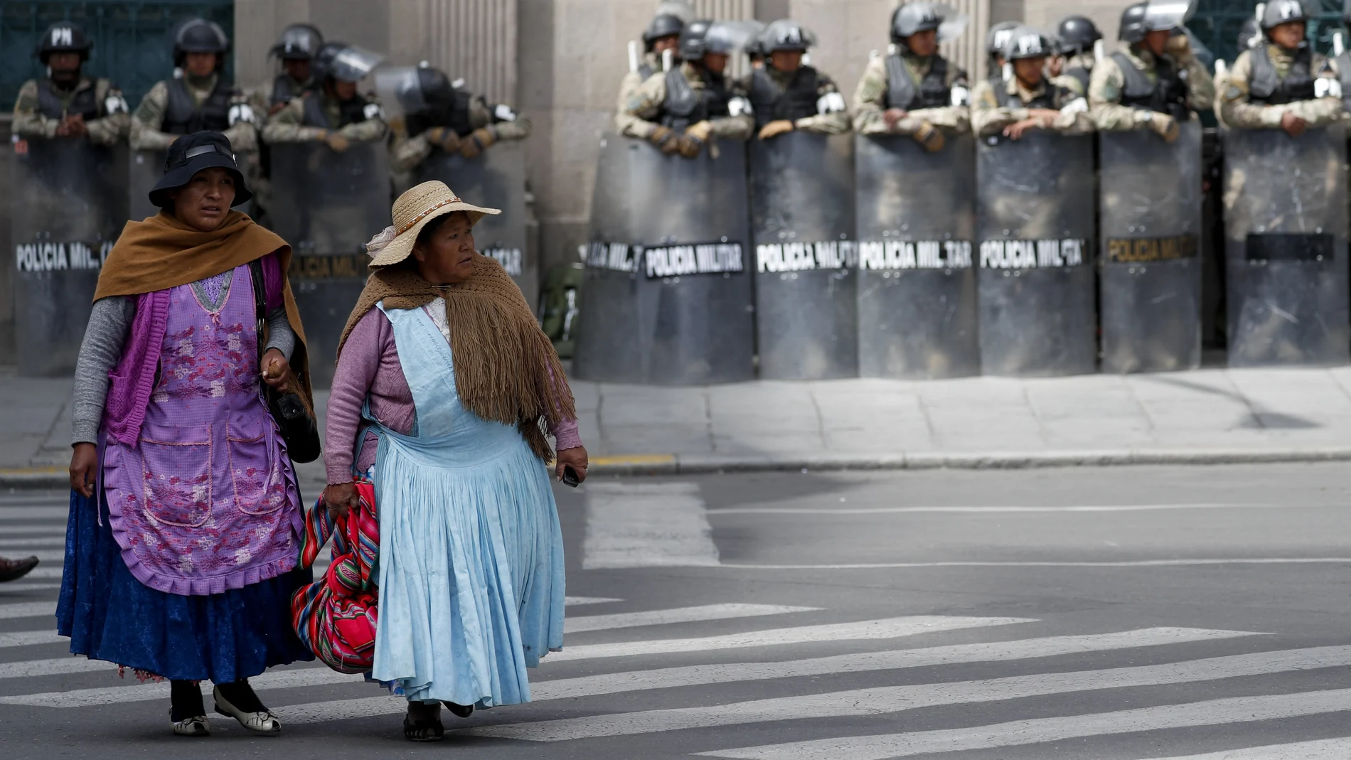 Dos mujeres pasan junto al palacio presidencial de La Paz, fuertemente protegido por las Fuerzas de Seguridad
