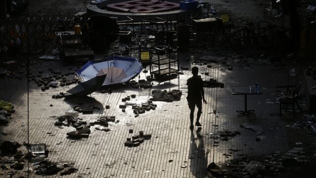 Un periodista camina entre los restos de la manifestación del campus de la Universidad Politécnica de Hong Kong (AP Photo/Achmad Ibrahim)