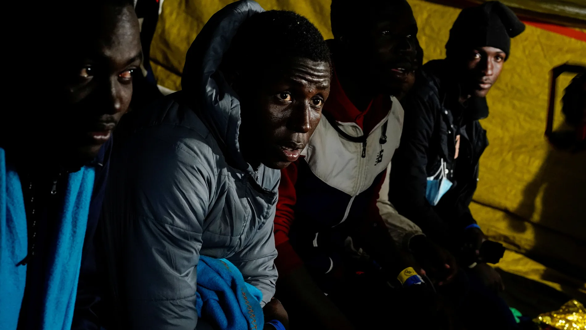 Migrants rest onboard the Proactiva Open Arms NGO rescue boat, sailing the Mediterranean Sea towards the Italian port of Taranto