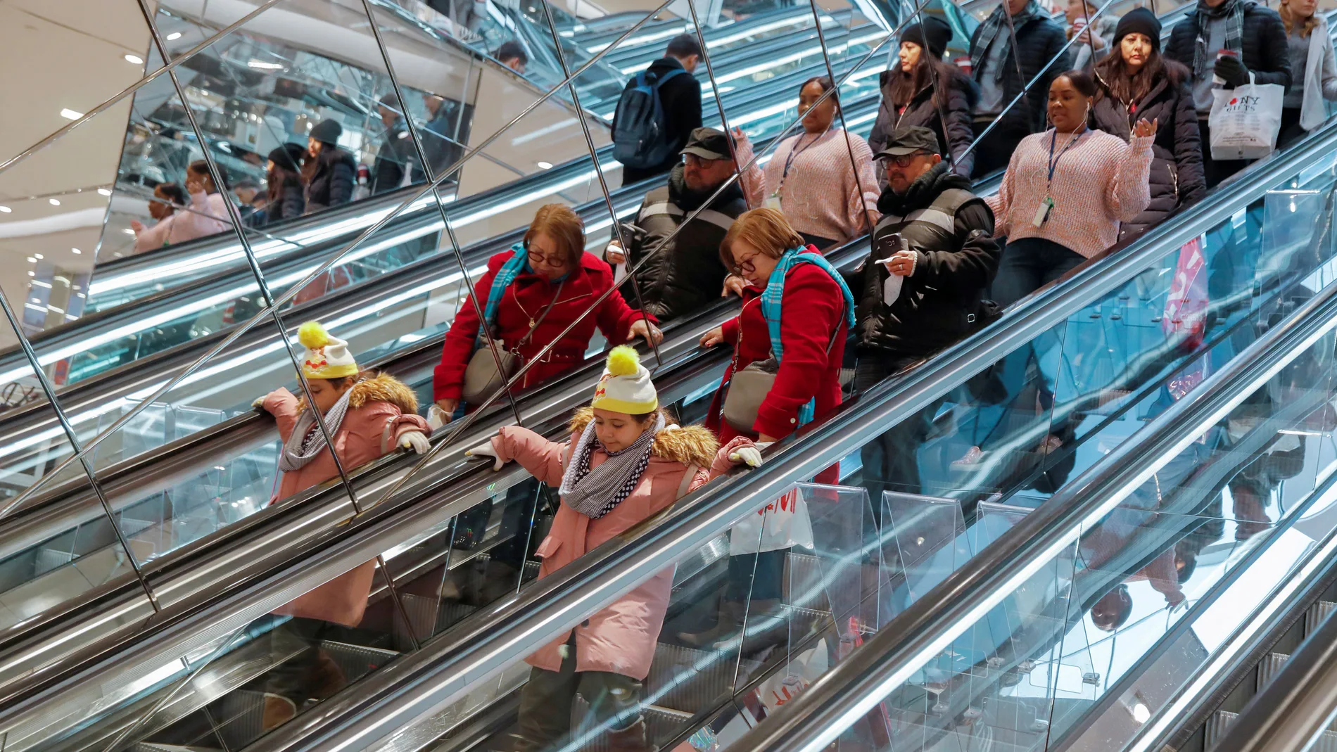 FILE PHOTO: People ride an escalator in H & M during a Black Friday sales event in Manhattan, New York City