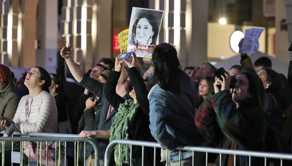 Manifestantes portan imágenes de Daphne Caruana Galizia después de las dimisiones en cadena
