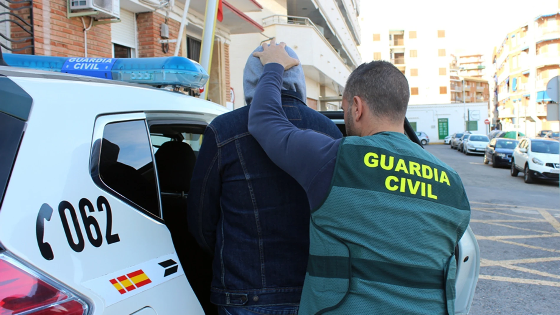 Un agente de la Guardia Civil con uno de los detenidos en Mazarrón por trata de personas