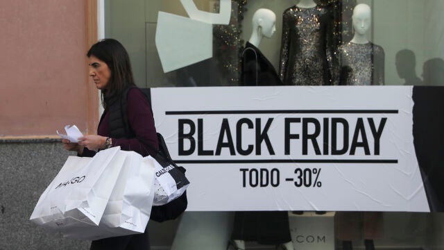Una mujer pasa por delante del escaparate de una tienda durante la jornada del "Black Friday"