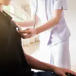 Imagen de archivo de una sanitaria auscultando a un paciente