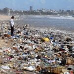 Un hombre observa una montaña de residuos plásticos a orillas del Mar Arábigo en Bombay, el 5 de junio de 2010. Se calcula que cada minuto se venden en el mundo un millón de botellas de agua fabricadas con plástico y que cada año se usan un billón de bolsas de ese material. El medio ambiente es el mayor reto que afronta la humanidad para sobrevivir