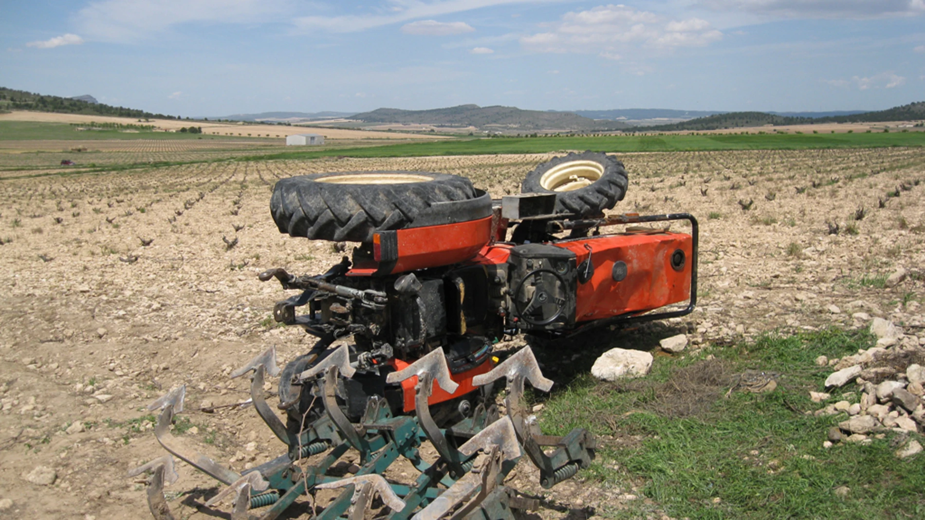 Imagen de un tractor volcado en el campo