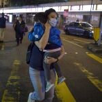 Una mujer lleva a su niño en brazos durante la manifestación prodemocracia de este domingo en Hong Kong.(AP Photo/Ng Han Guan)