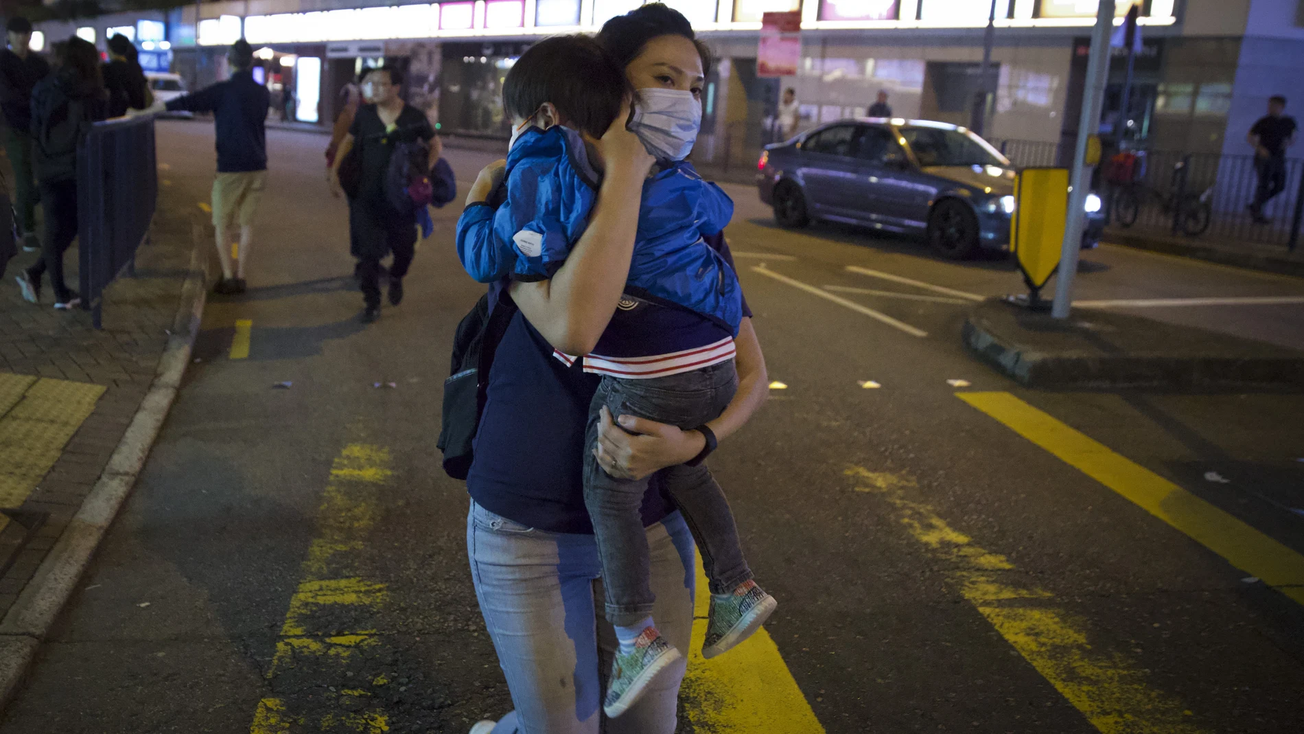 Una mujer lleva a su niño en brazos durante la manifestación prodemocracia de este domingo en Hong Kong.(AP Photo/Ng Han Guan)