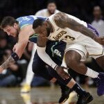 Doncic y LeBron James pelean por el control del balón en el Staples