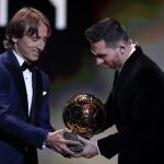 Barcelona's soccer player Lionel Messi, right, receives his sixth golden ball from Real Madrid's Lucas Modric during the Golden Ball award ceremony in Paris, Monday, Dec. 2, 2019. (AP Photo/Francois Mori)