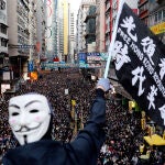 Un manifestante con la icónica máscara de Guy Fawkes ondea una bandera durante una marcha del Día de los Derechos Humanos, organizada por el Frente Civil de Derechos Humanos, en Hong Kong, China, el 8 de diciembre de 2019. REUTERS / Danish Siddiqui