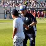 Maradona, con un aficionado durante un partido de Gimnasia / Efe