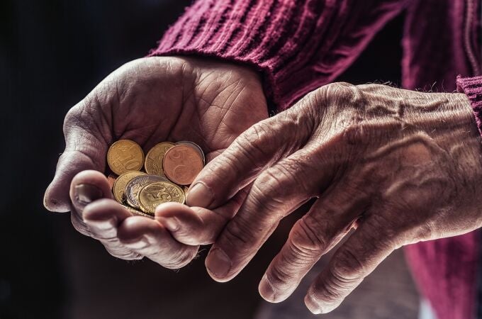 Monedas en las manos de una persona mayor
