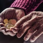 Monedas en las manos de una persona mayor