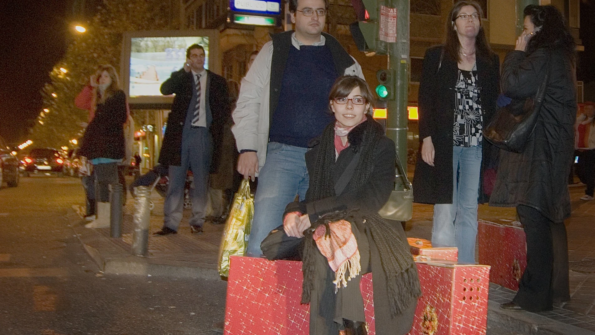 Un grupo de trabajadores espera en una parada de taxi con sus cestas de Navidad en Madrid./Foto: Gonzalo Pérez