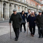 Ancianos pasean por la plaza mayor de Madrid
