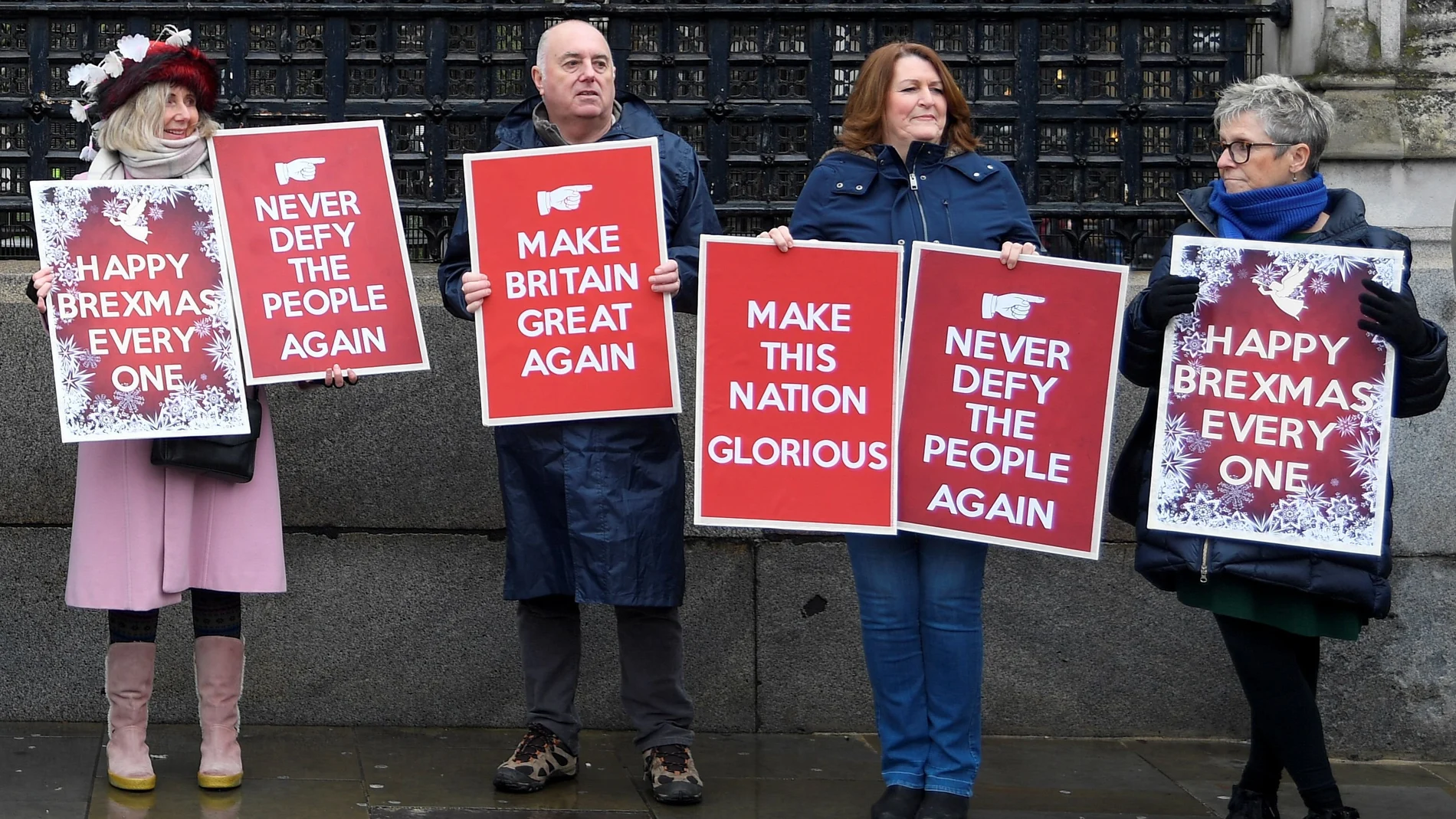 Pro-Brexit demonstrators hold signs outside the Houses of Parliament in London