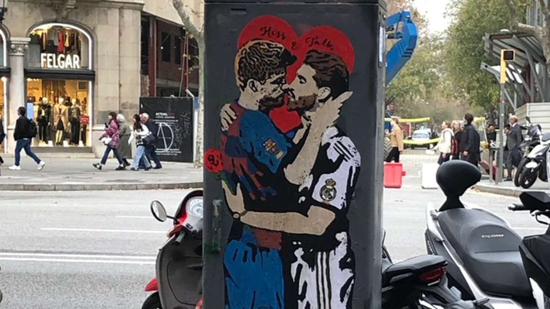 Un grafiti de Piqué y Messi besándose, en el barrio de Gracia